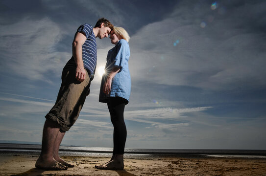 A couple touching heads at sunset on a beach