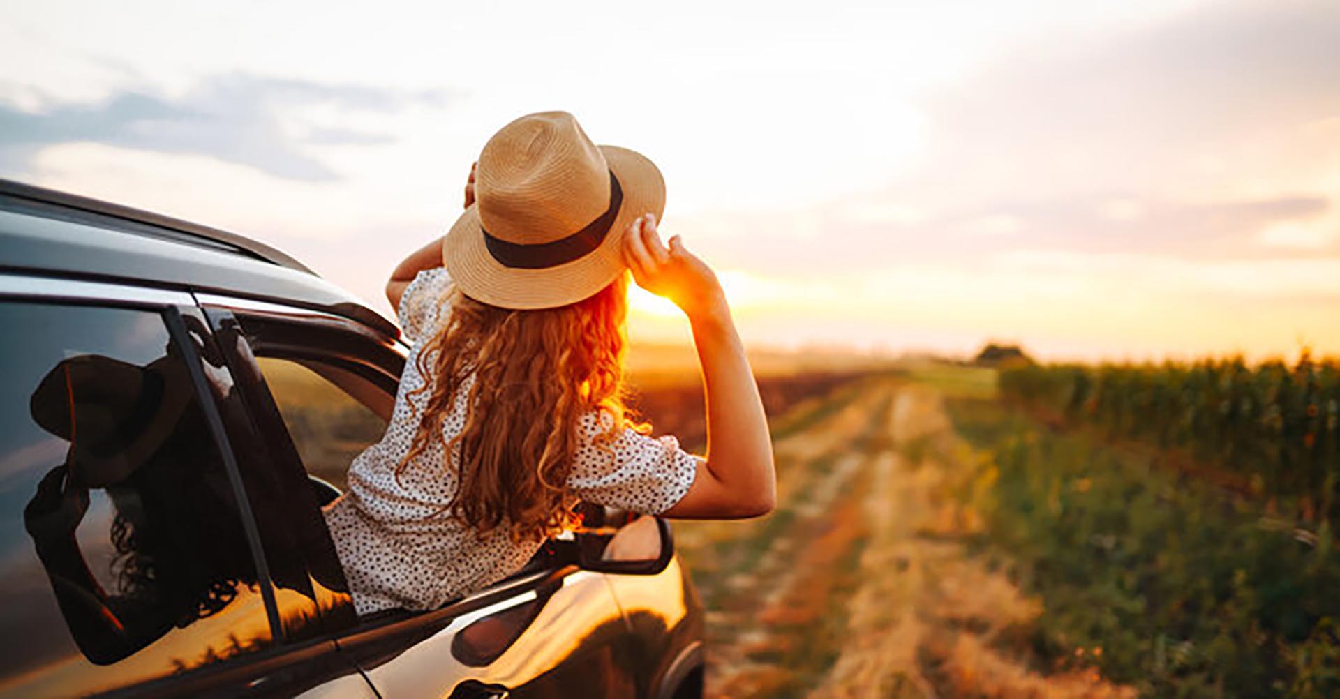 A woman leaning out of a car window, enjoying a sense of freedom
